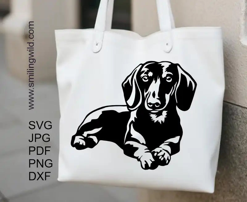 a tote bag withs a design decal of a dachshund in lying position crafted of PNG and DXF files that are included with the Dog Clipart for Cutting file set, showing clean lines and file formats.